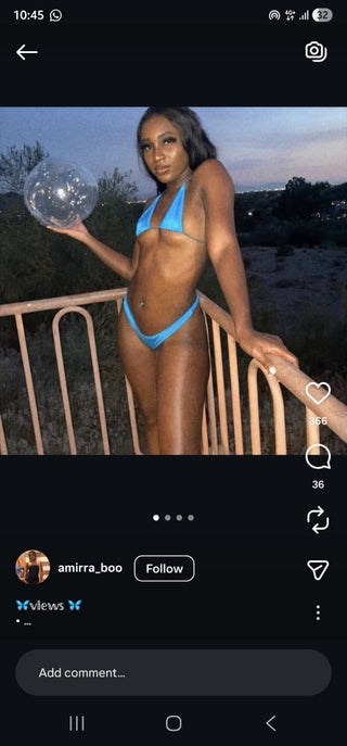 Person in a blue bikini holding a crystal ball on a balcony.